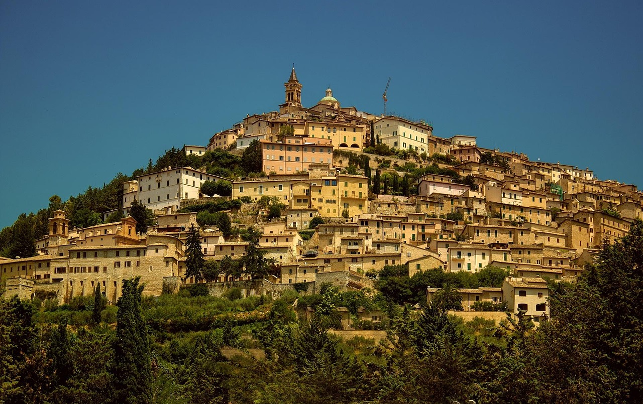 Vista panoramica del paese caratteristico delle Marche con architettura storica e paesaggi naturali.