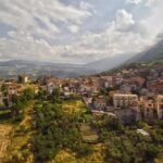 Vista panoramica del borgo laziale, con stradine pittoresche e case in pietra immerse nel verde.