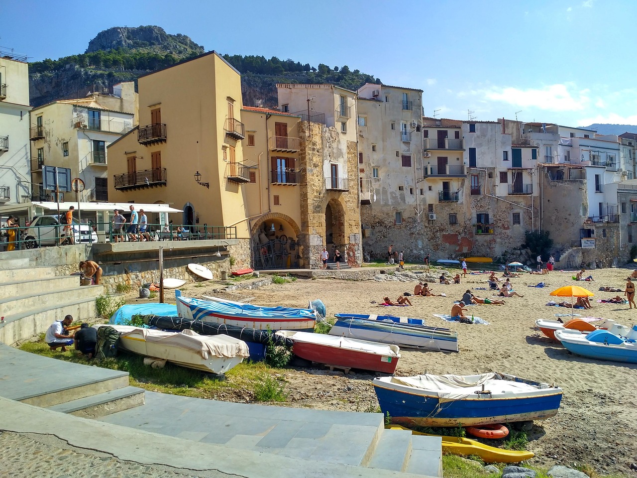 Vista panoramica di una spiaggia deserta in Sicilia, circondata da scogliere e acque cristalline.