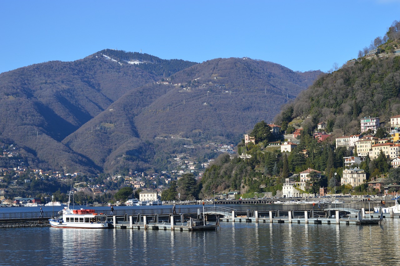 Vista panoramica del Lago di Como con ville storiche e battelli in navigazione a marzo.