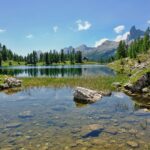 Un lago tranquillo in Italia, circondato da natura, ideale per nuotare e picnic estivi.