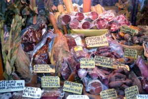 Mercato storico piemontese con bancarelle di prodotti tipici e visitatori tra colori e tradizioni locali.