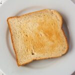 Fette biscottate in primo piano con etichetta di una marca controversa per salute.