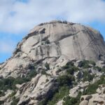 Turisti che partecipano a una festa tradizionale in Sardegna, circondati da artigianato locale.